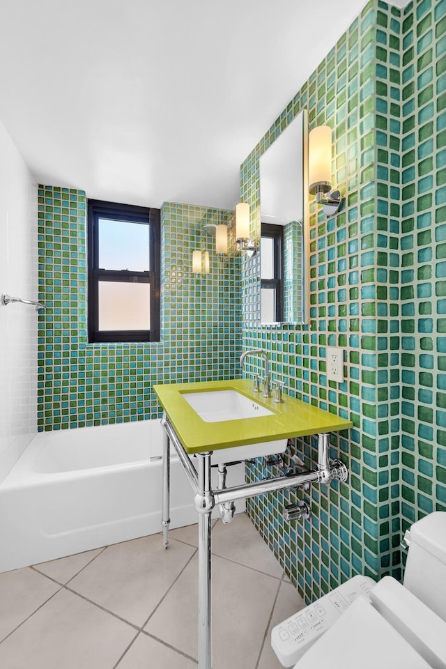 full bathroom with a sink, tile patterned flooring, tile walls, toilet, and a bathtub