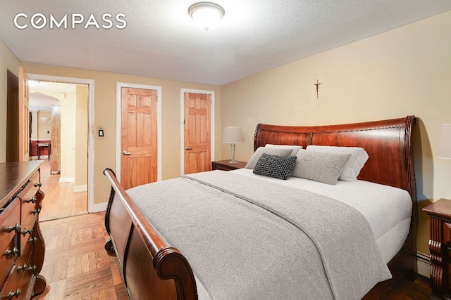 bedroom featuring parquet flooring and a baseboard heating unit