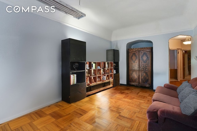 living area featuring arched walkways and baseboards