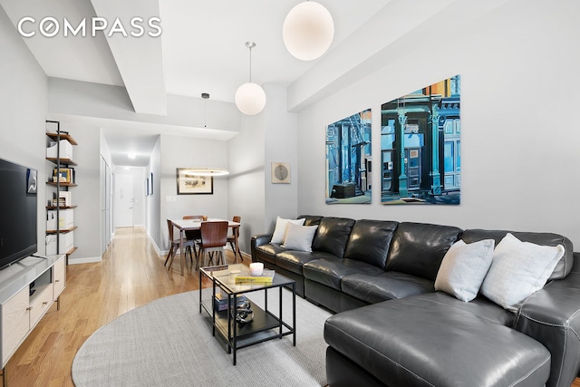 living room featuring light wood-type flooring and baseboards