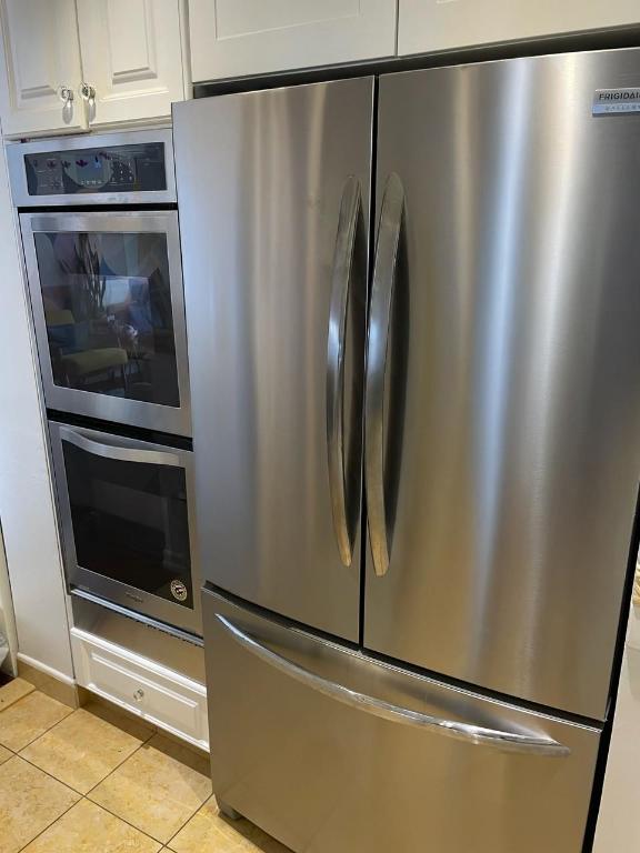 kitchen featuring light tile patterned floors, white cabinetry, and appliances with stainless steel finishes