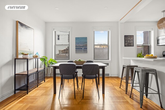 dining space featuring radiator and light parquet floors