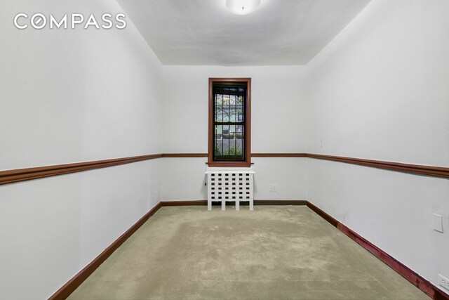 carpeted spare room featuring baseboards