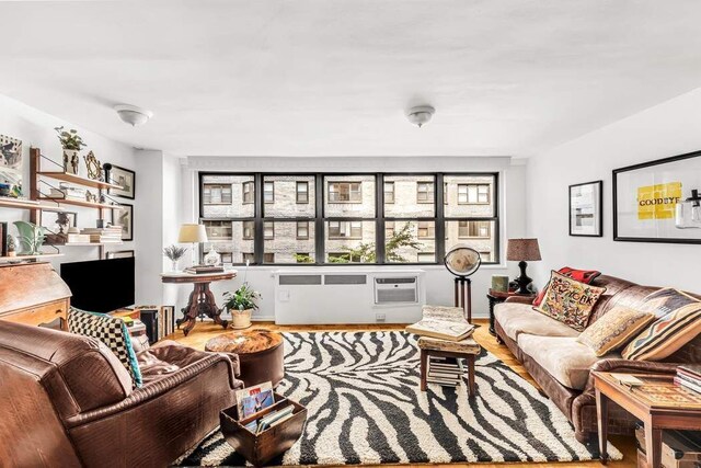 209 E 56th St Unit 5Abc, New York City, NY 10022 - living room featuring a wall mounted air conditioner and wood finished floors