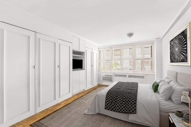 209 E 56th St Unit 5Abc, New York City, NY 10022 - bedroom with radiator heating unit, crown molding, and light wood finished floors