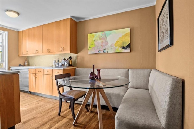 kitchen featuring light hardwood / wood-style floors, dishwasher, breakfast area, and crown molding