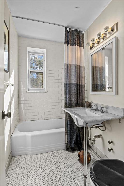 bathroom with tile patterned flooring and tiled shower / bath