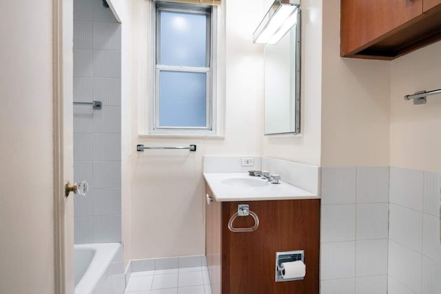 bathroom featuring tile patterned floors, vanity, and a washtub