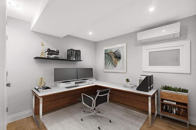 office area with a wall mounted AC and light hardwood / wood-style flooring