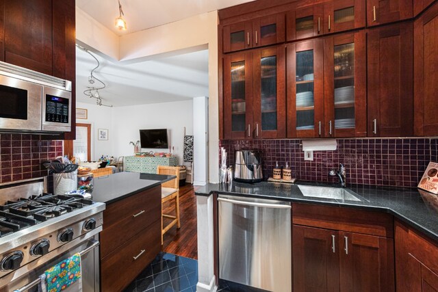 kitchen with backsplash, dark wood-type flooring, sink, and stainless steel appliances