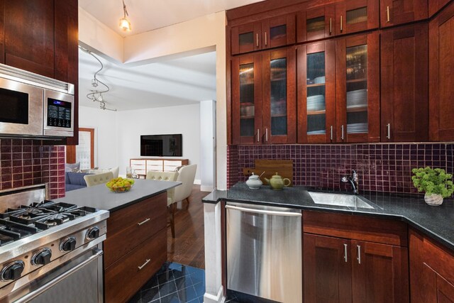 kitchen featuring decorative backsplash, appliances with stainless steel finishes, sink, and dark hardwood / wood-style flooring