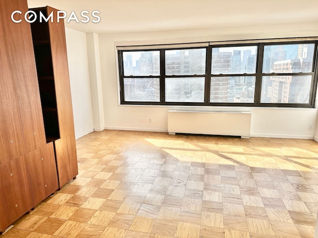 empty room with baseboards and radiator