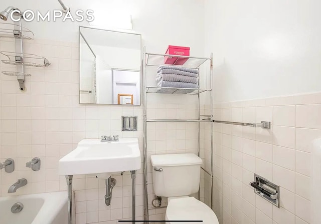 full bathroom featuring shower / washtub combination, toilet, and tile walls