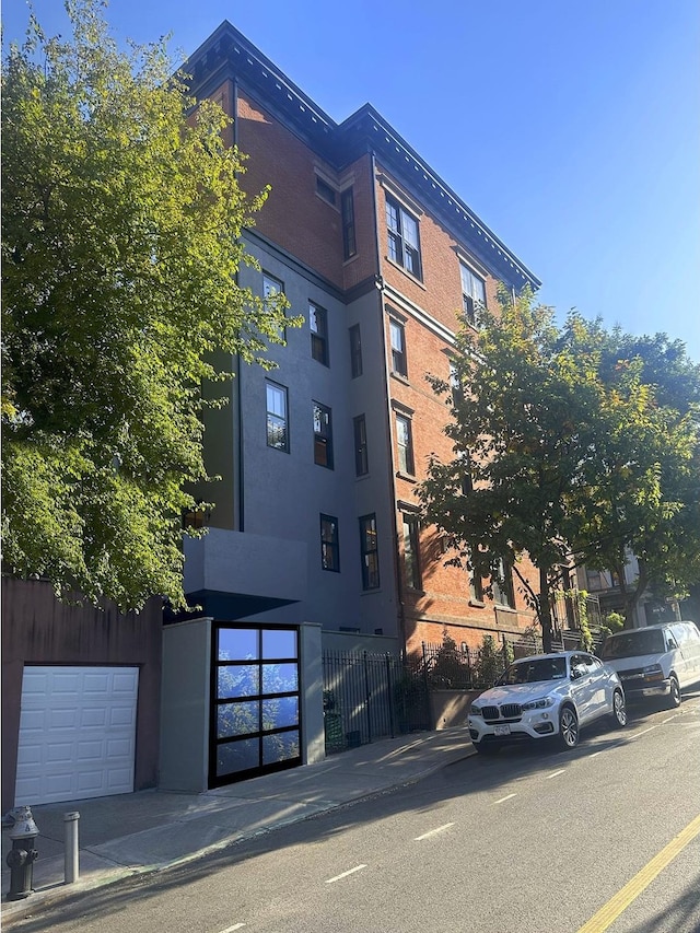 view of building exterior with a garage and fence