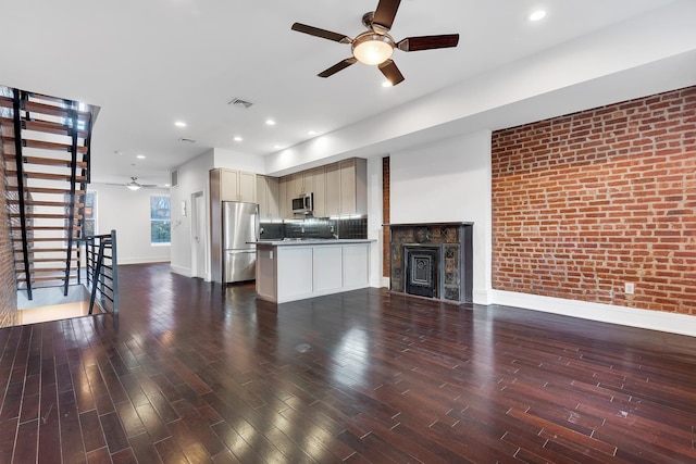 kitchen featuring brick wall, wood finished floors, visible vents, open floor plan, and appliances with stainless steel finishes