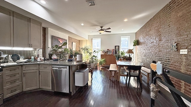 kitchen featuring visible vents, dark stone counters, a ceiling fan, dark wood-style flooring, and stainless steel dishwasher