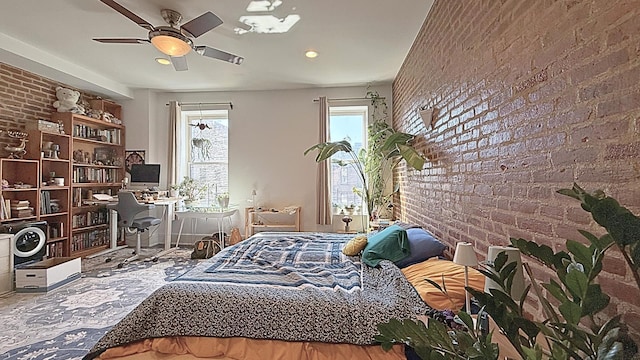 bedroom with brick wall, a ceiling fan, and an accent wall