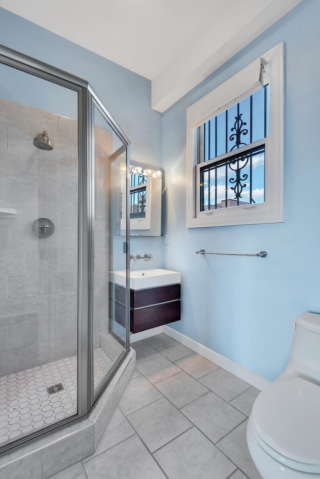 bathroom with toilet, a shower stall, baseboards, and vanity