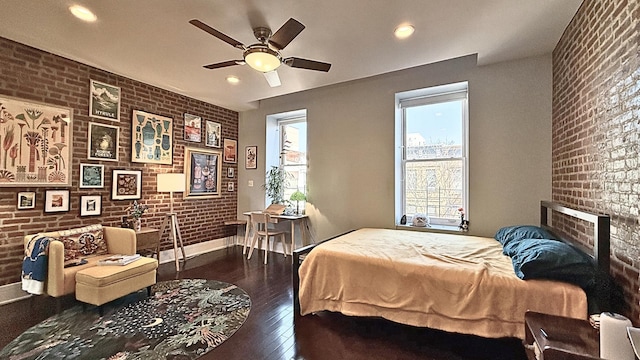 bedroom with a fireplace, recessed lighting, hardwood / wood-style floors, brick wall, and baseboards