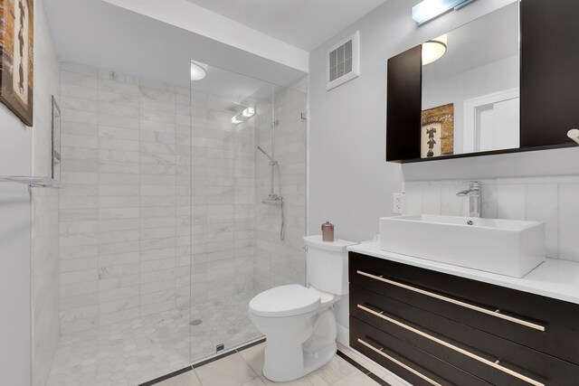 bathroom with vanity, visible vents, toilet, and a stall shower