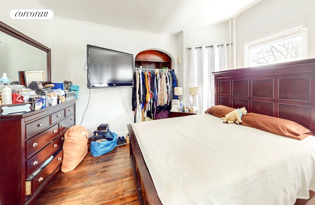bedroom featuring ornamental molding, a closet, visible vents, and wood finished floors