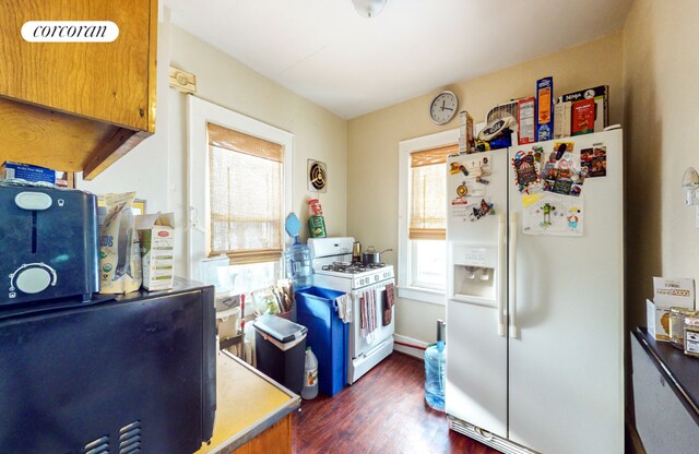 empty room featuring radiator, a healthy amount of sunlight, and dark hardwood / wood-style floors