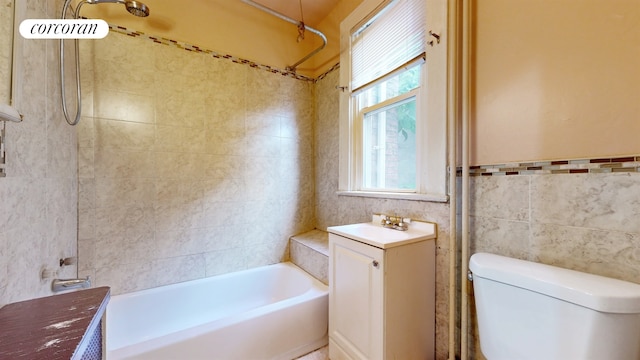 bathroom with tile walls, bathing tub / shower combination, toilet, and vanity