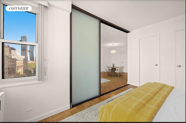 bedroom featuring light parquet flooring and a closet