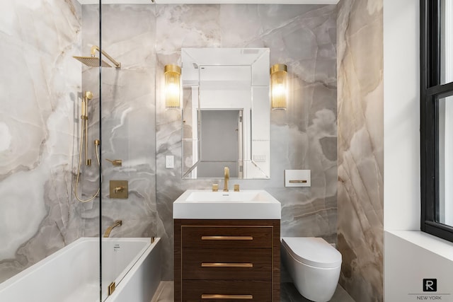 full bath featuring toilet, shower / bath combination, vanity, and tile walls