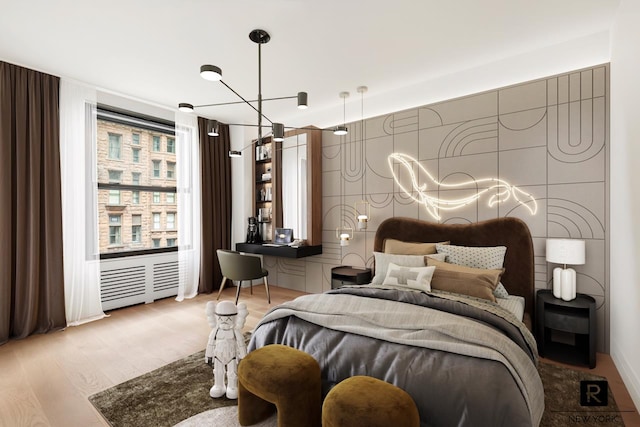bedroom with wood finished floors and a chandelier