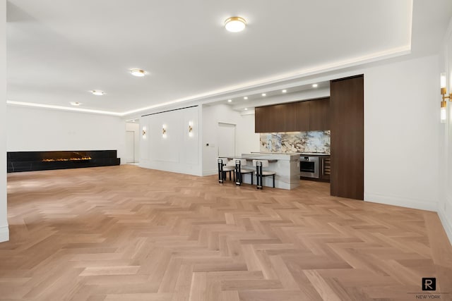 living room with baseboards, a warm lit fireplace, and recessed lighting