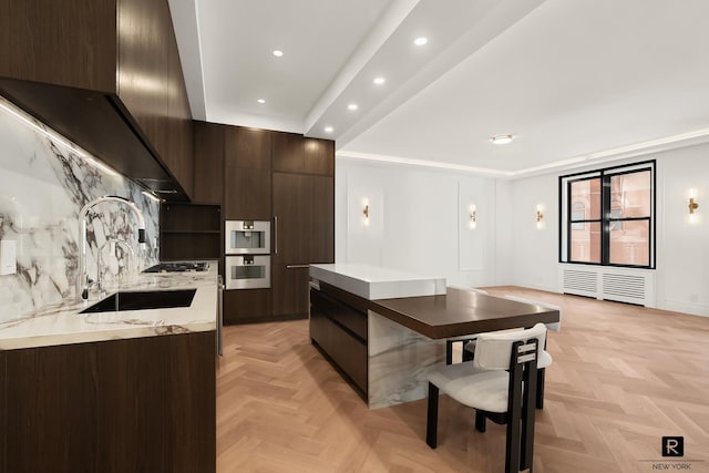 kitchen featuring dark brown cabinets, modern cabinets, a sink, and light countertops