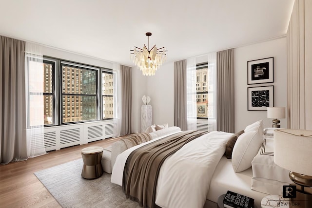 bedroom featuring wood finished floors and a chandelier