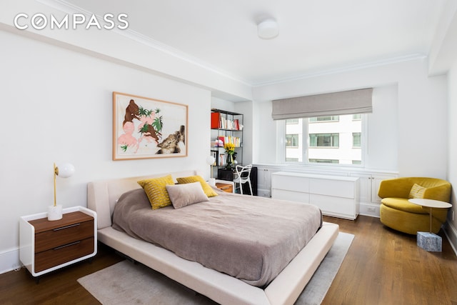 bedroom featuring dark wood-style floors, baseboards, and crown molding