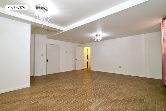 spare room featuring visible vents, baseboards, and wood finished floors