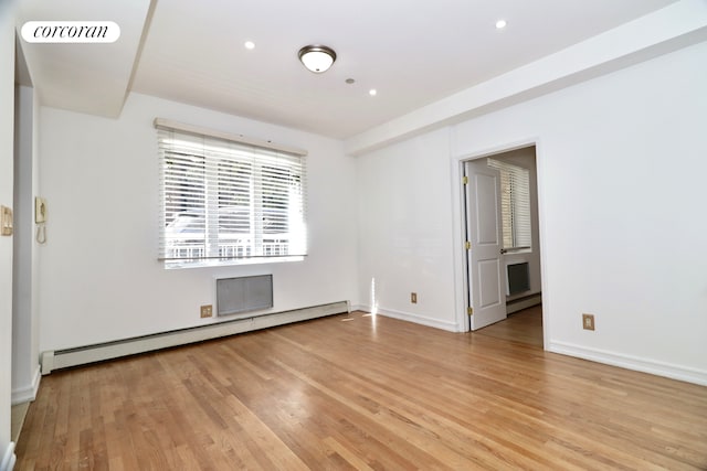 unfurnished room with light wood finished floors, visible vents, a baseboard heating unit, baseboards, and a baseboard radiator