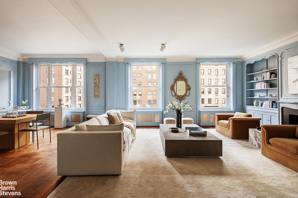 living room with wood-type flooring, built in features, and ornamental molding