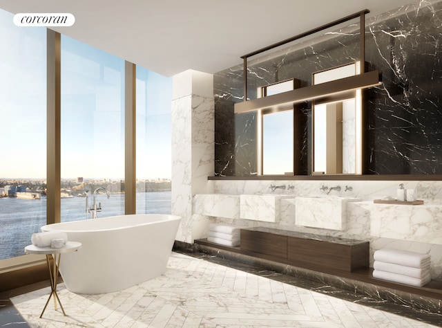 full bath with visible vents, marble finish floor, expansive windows, vanity, and a freestanding tub