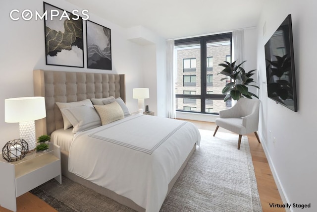 bedroom with baseboards and wood finished floors