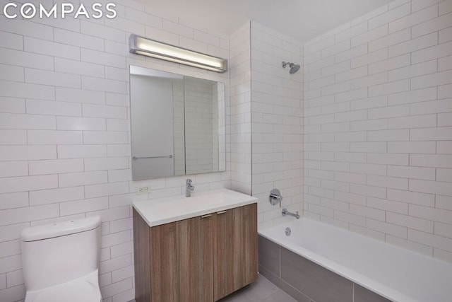 full bathroom with toilet, vanity, tile walls, tile patterned flooring, and tiled shower / bath combo