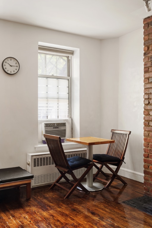 dining space featuring radiator heating unit, cooling unit, dark hardwood / wood-style flooring, and breakfast area