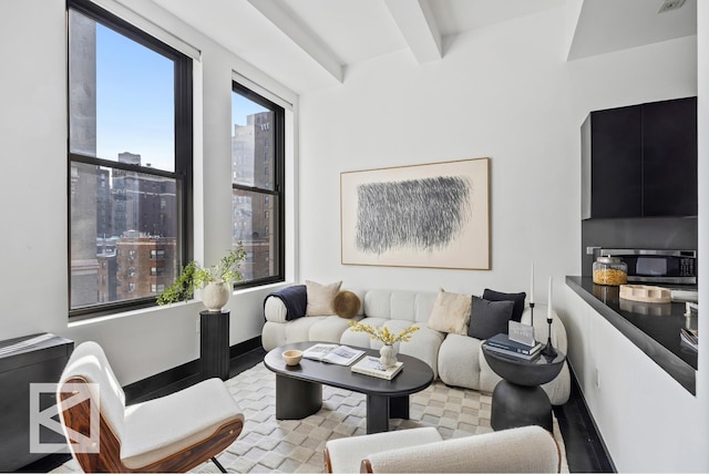 living room featuring beamed ceiling and baseboards