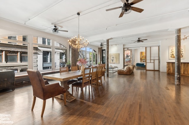 dining area with ceiling fan with notable chandelier, wood finished floors, and decorative columns