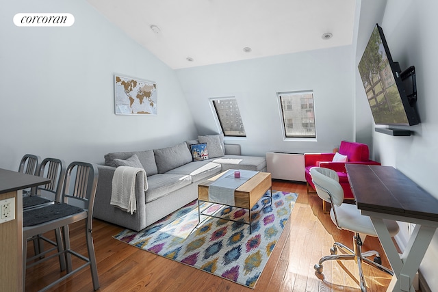 living area featuring visible vents, lofted ceiling, and wood-type flooring