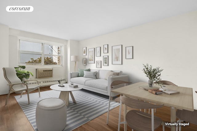 living room with wood finished floors, an AC wall unit, and visible vents