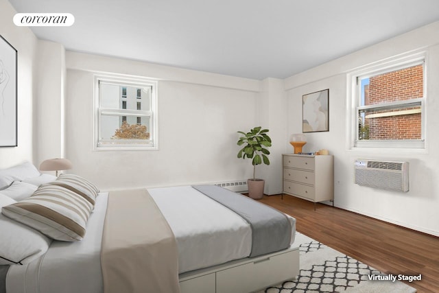 bedroom featuring wood finished floors, a wall mounted air conditioner, and visible vents