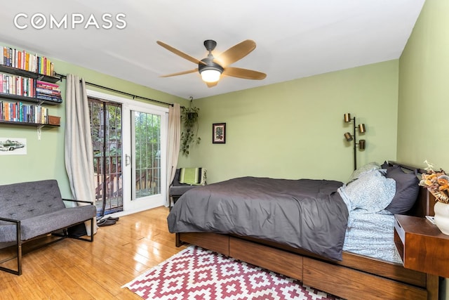 bedroom with access to exterior, wood-type flooring, and ceiling fan