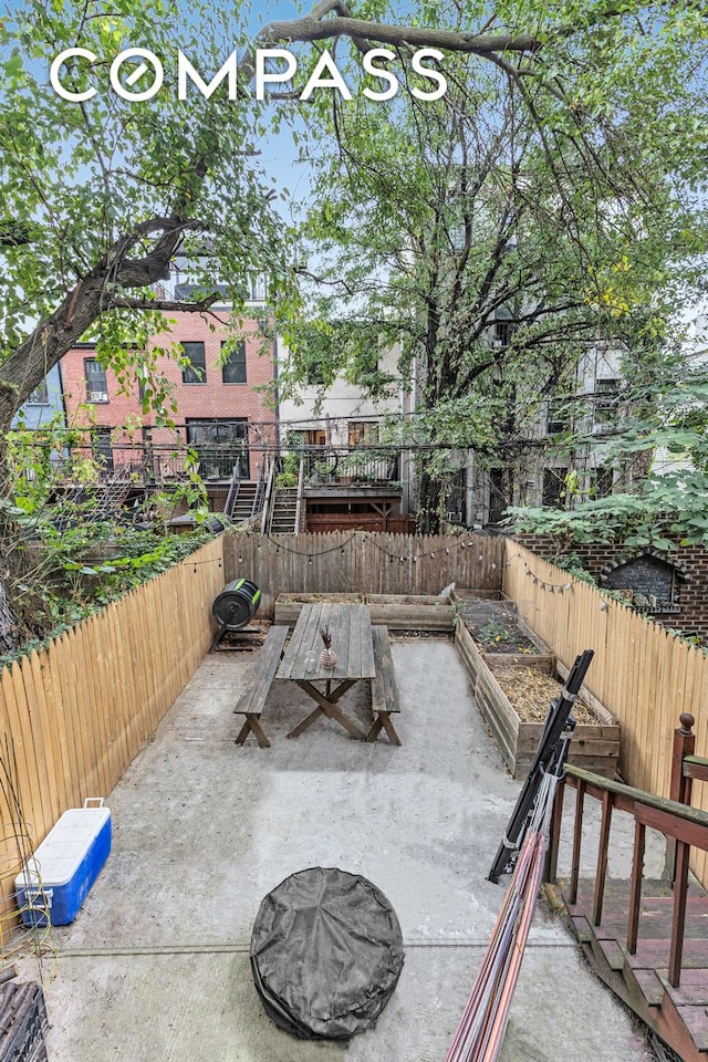 view of patio with fence and a vegetable garden