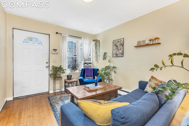 living room with baseboard heating and wood-type flooring