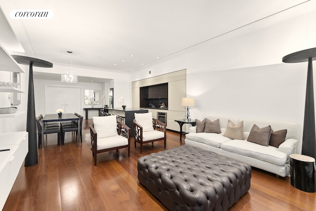 living room featuring wood finished floors, visible vents, and a notable chandelier